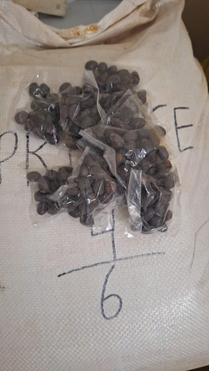 Small bags of dark seeds on a white cloth with text