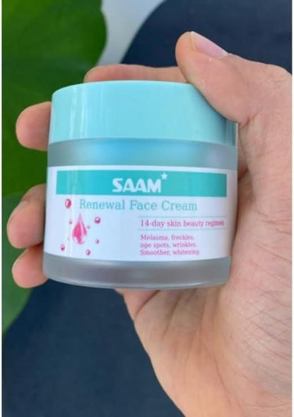 Hand holding a jar of SAAM Renewal Face Cream with a green leaf background