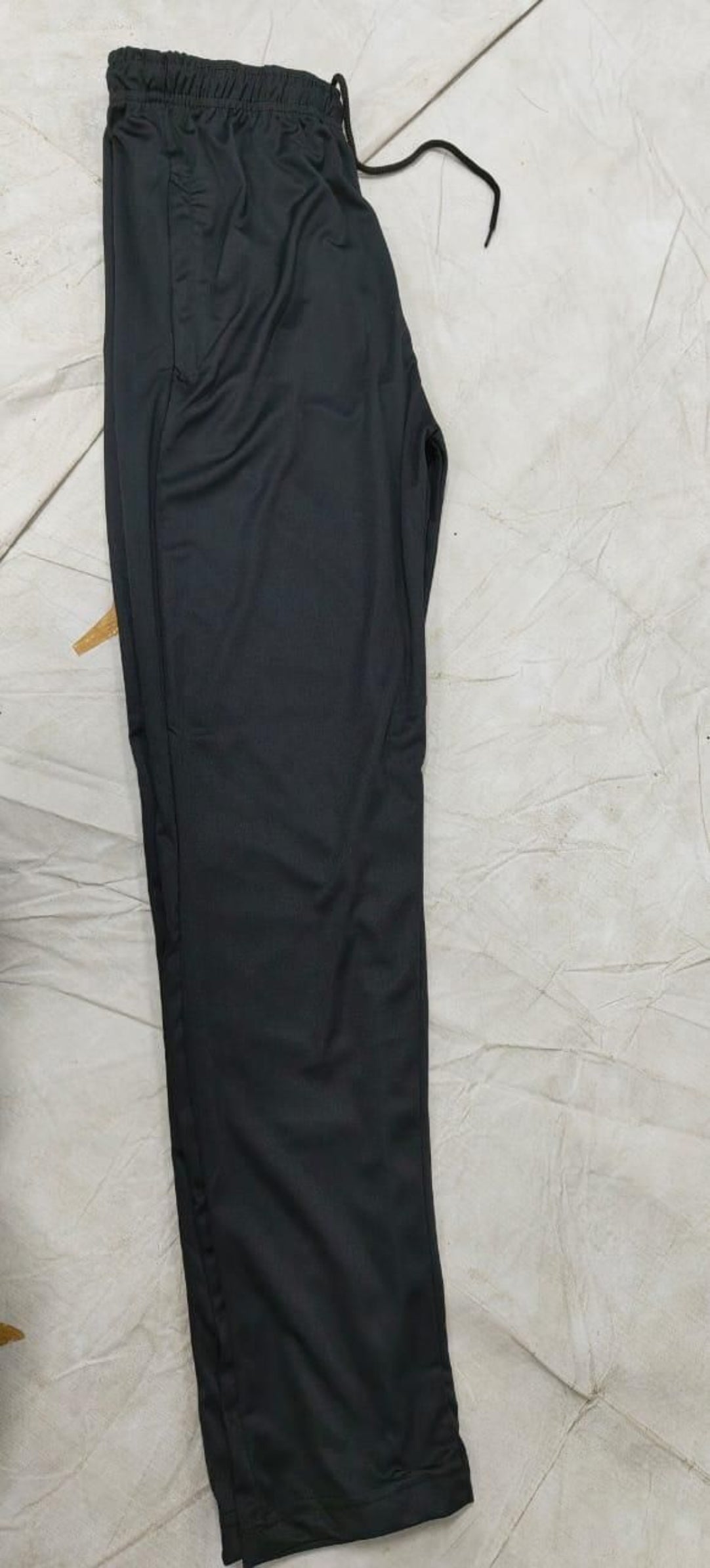 Black pants on a light tiled floor