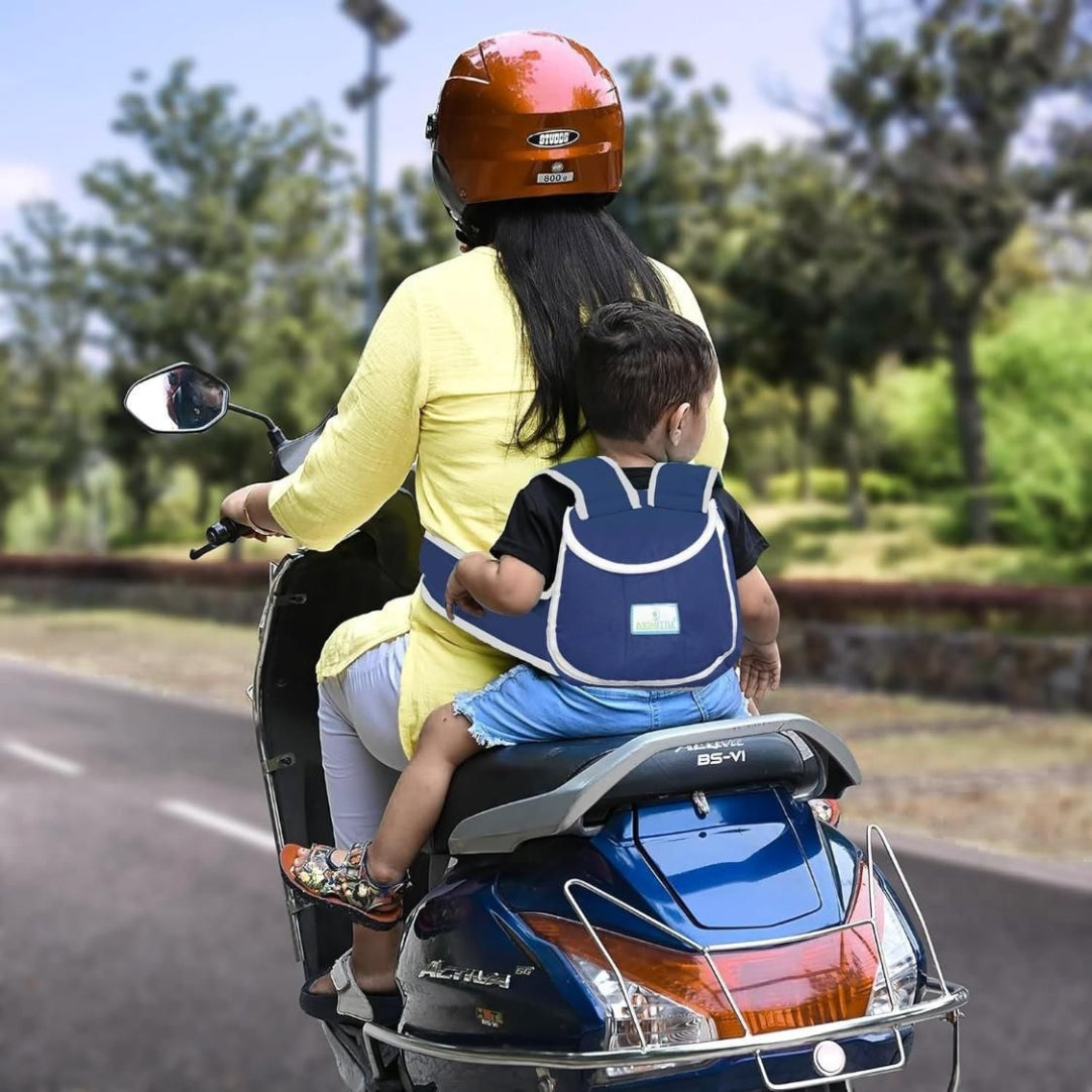 Woman and child riding a scooter with a child seat and helmet on a road.