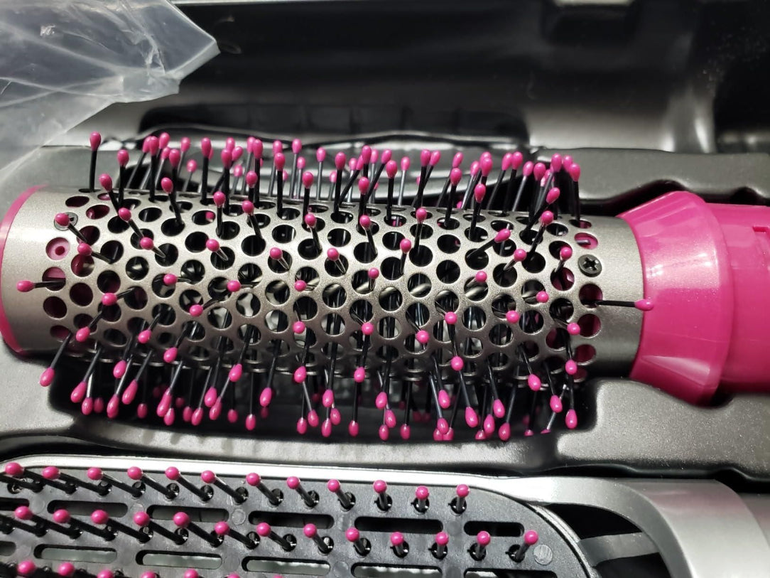 Hairbrush with pink bristles on a metallic background