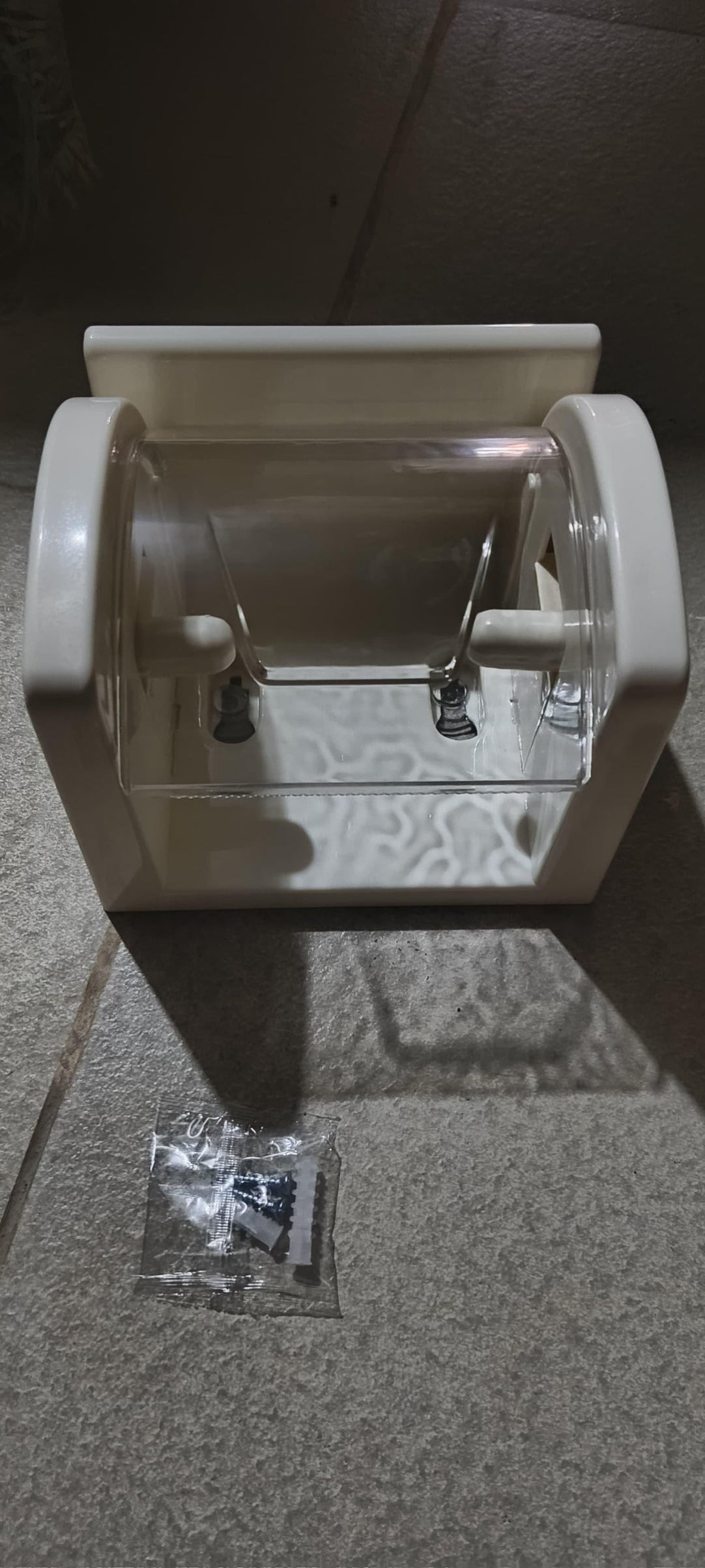 White paper towel holder on a tiled floor