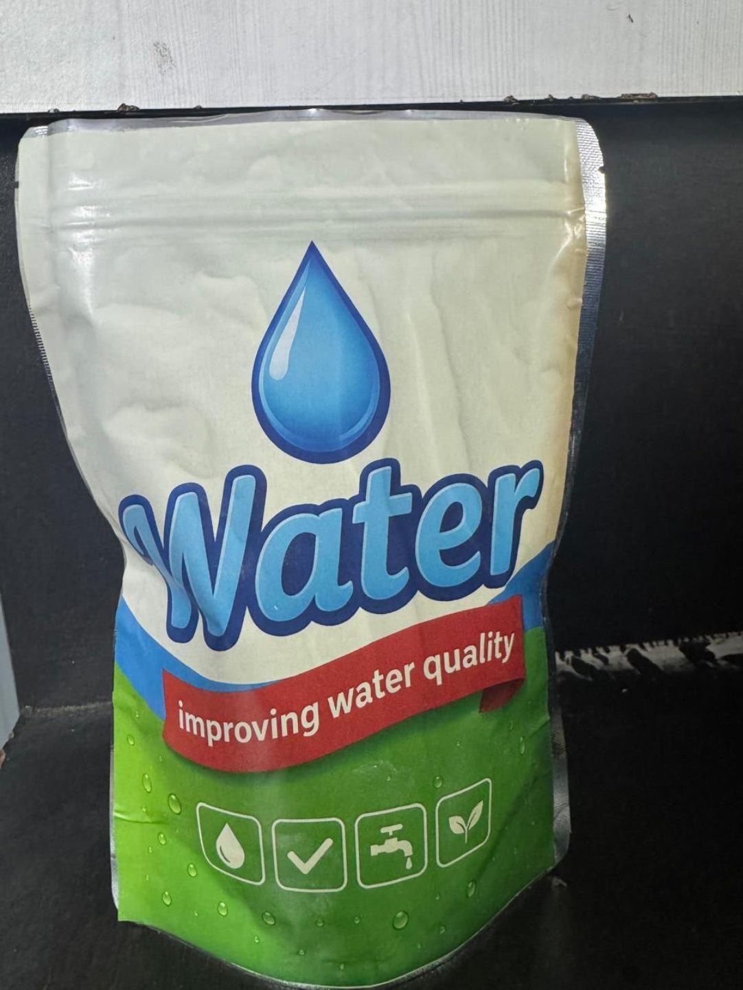 Packaging of water with a blue droplet symbol on a white background