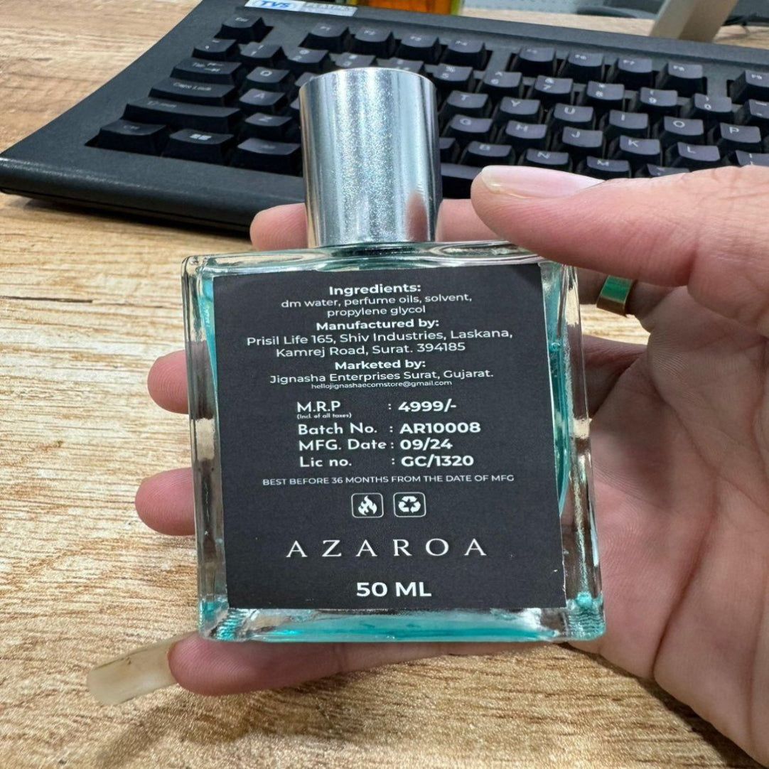 Hand holding a small bottle labeled 'AZAROA' with a keyboard in the background