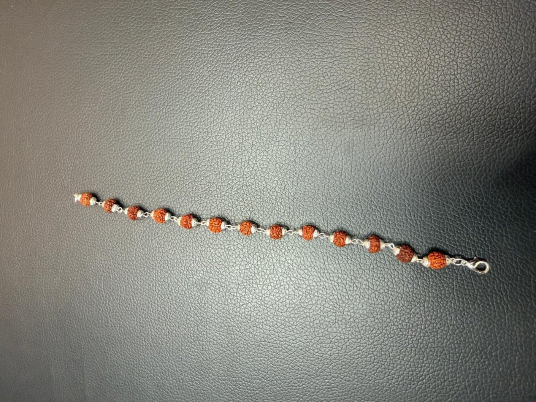 Bracelet with red and white beads on a gray surface