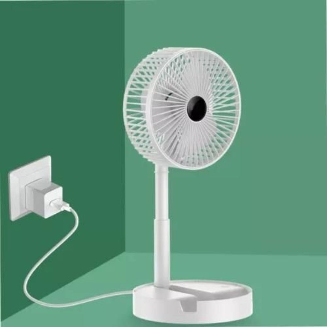 White desk fan plugged into a wall socket on a green background