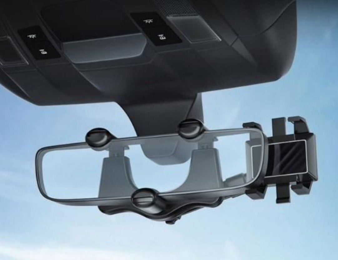 A black mirror mobile phone holder for car attached to a vehicle's rearview mirror.