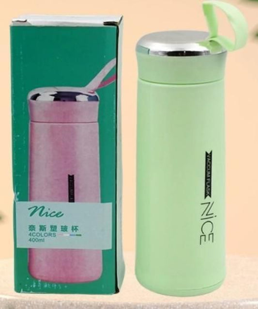 Green thermos with 'Nice' branding next to its packaging on a beige background