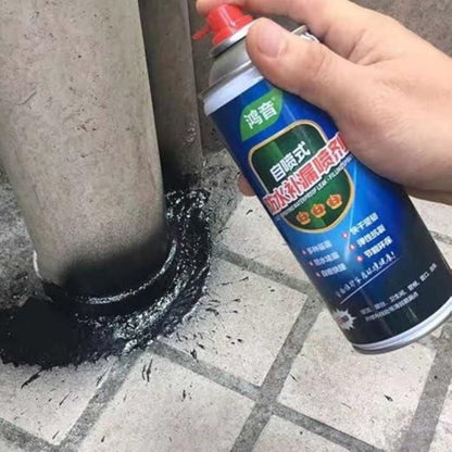 Hand applying black sealant to a crack using an aerosol can on a concrete surface.