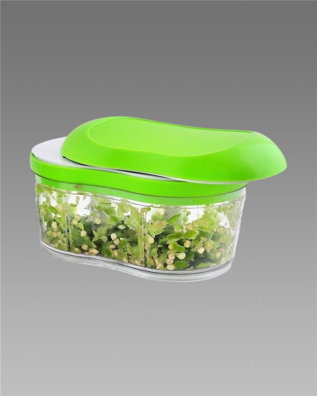 A manual hand push chopper slicer container with green lid, partially filled with chopped vegetables, showcasing the clear container and the green push mechanism.