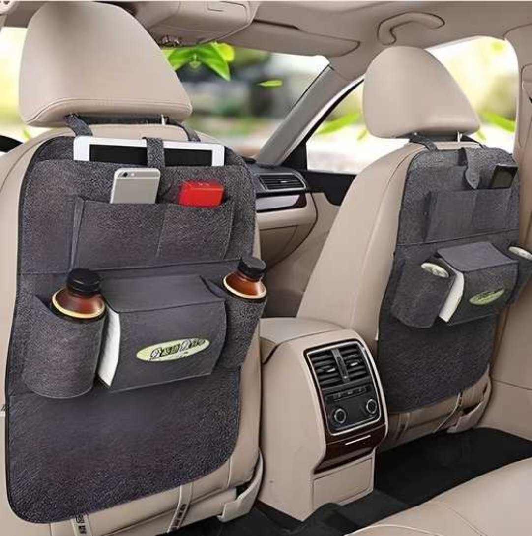 A car back seat storage organizer with multiple compartments, installed on a car's front seats holding various items such as a mobile phone and a bottle.