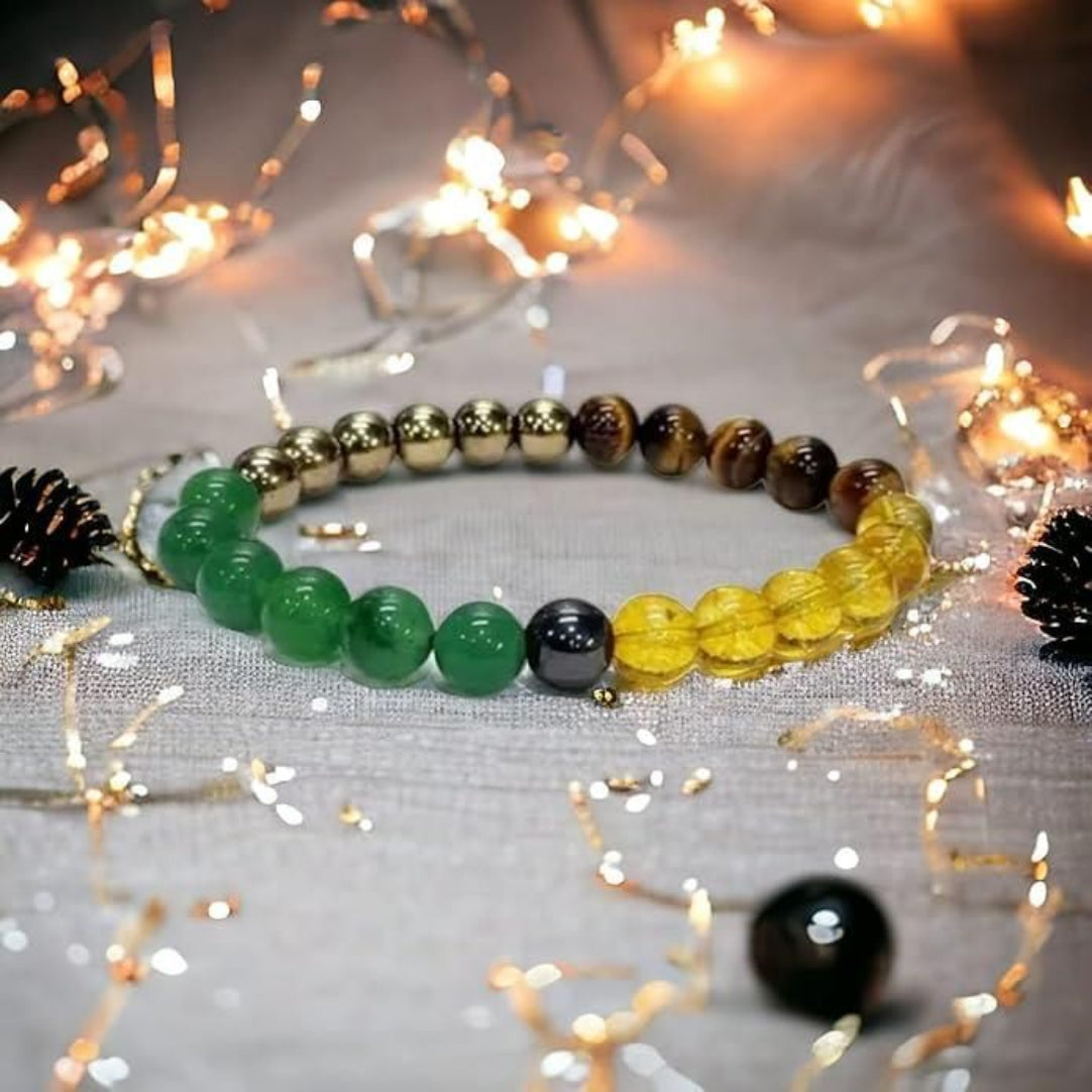 A beaded bracelet with green and yellow stones, displayed on a table with string lights in the background.