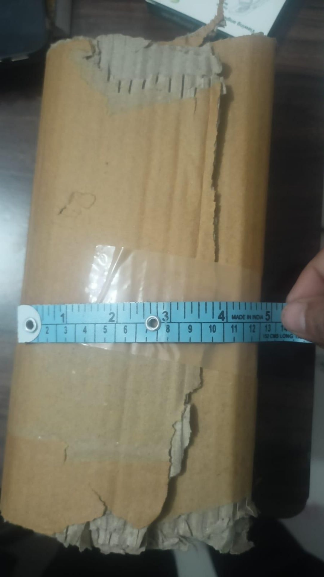 Cardboard box with a measuring tape indicating dimensions