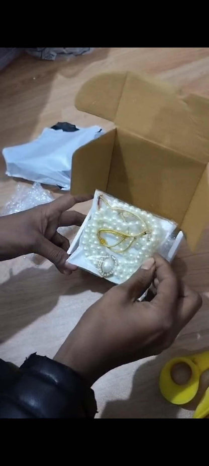 Person holding a small box with jewelry on a wooden surface