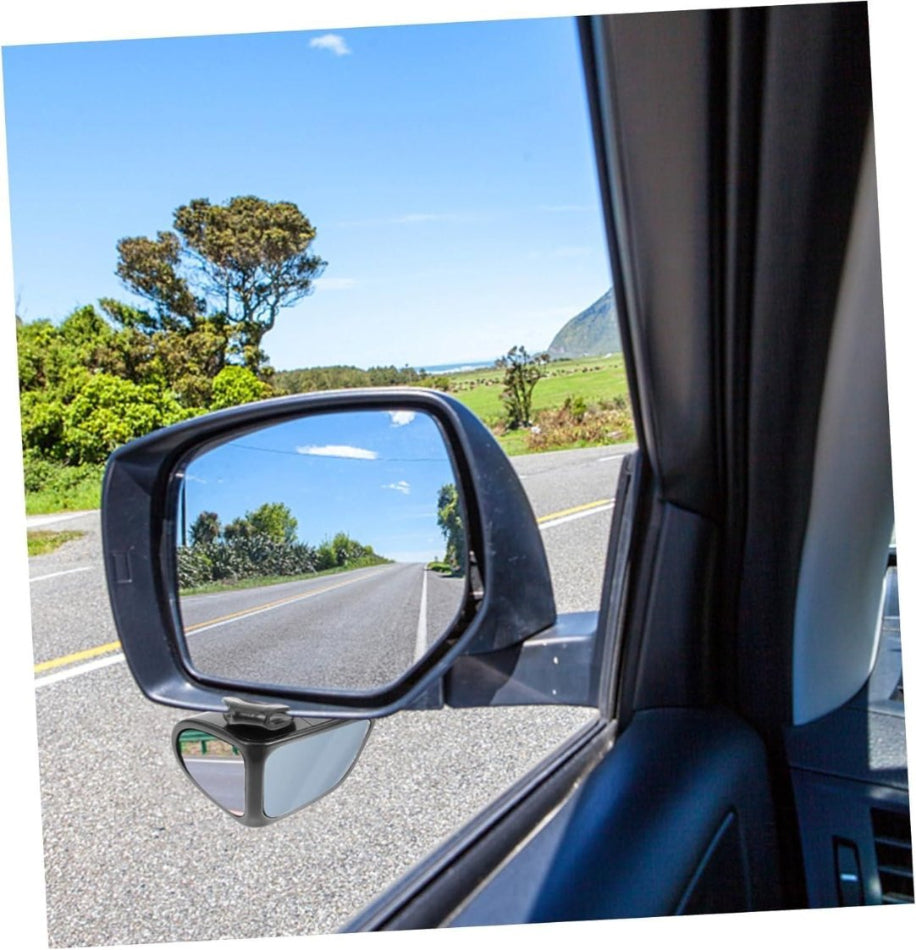 Car side mirror reflecting a road with trees and blue sky