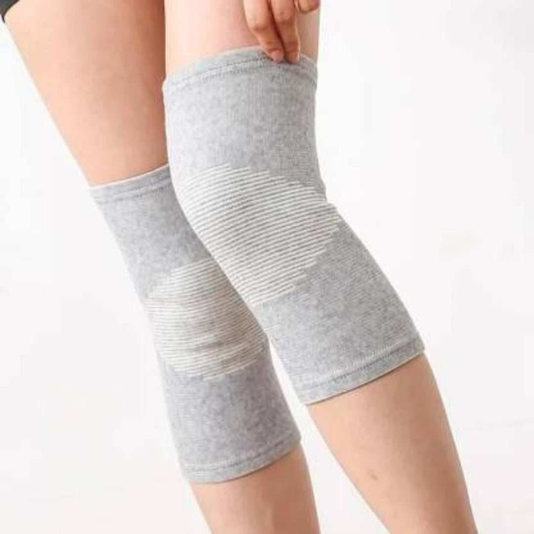 Gray knee sleeves on a person's legs against a white background