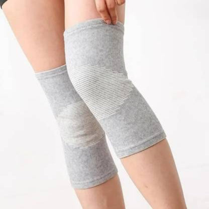 Gray knee sleeves on a person's legs against a white background