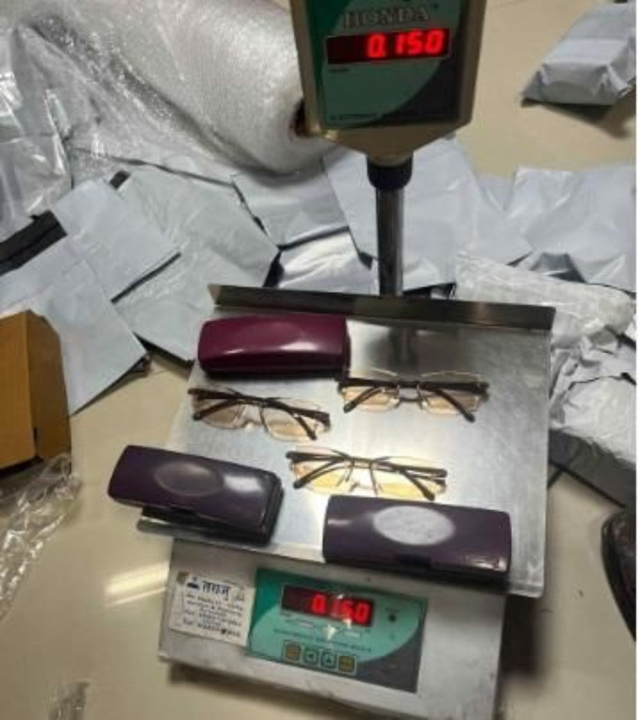 Glasses on a scale with digital display on a cluttered surface