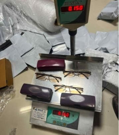 Glasses on a scale with digital display on a cluttered surface