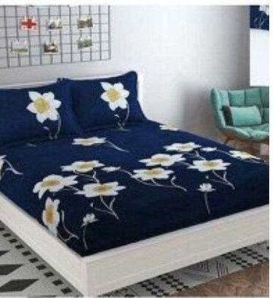 A double bedsheet set with floral pattern on a navy blue background, displayed on a bed with two pillowcases, in a room with decorative items on the walls.
