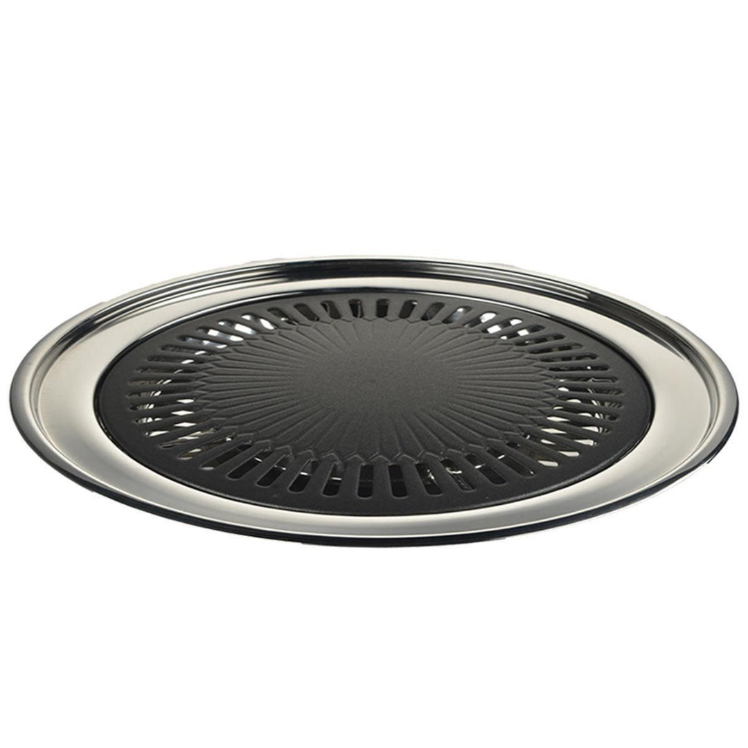 Round black grill pan with silver rim on a white background