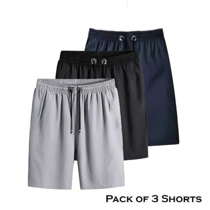 A pack of three men's shorts in different colors, showcasing a pair of gray shorts, a pair of black shorts, and a pair of navy blue shorts, all with elastic waistbands.