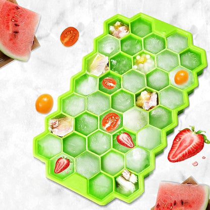 A green silicone ice cube tray filled with ice cubes and fruit pieces, placed on a kitchen counter.