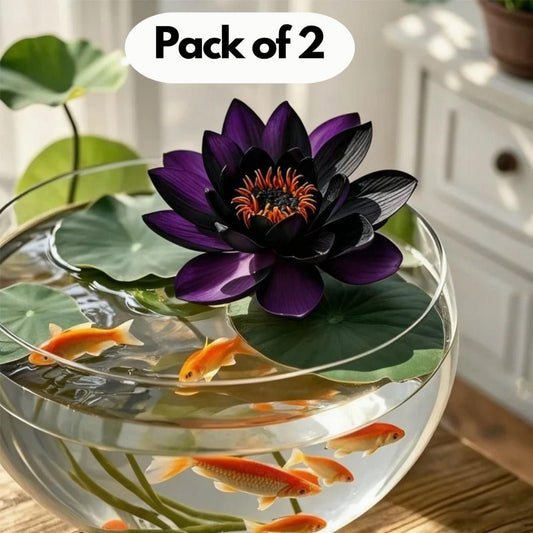Decorative fishbowl with purple artificial water lily and goldfish on a wooden surface.