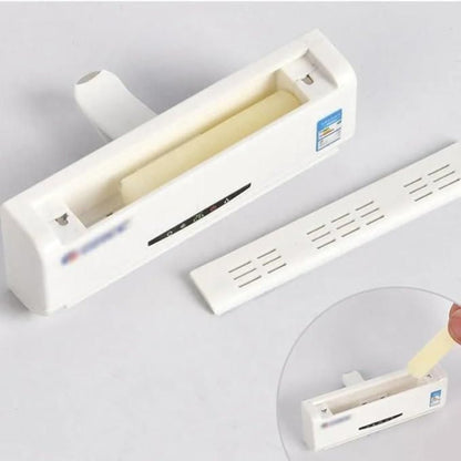 White plastic strip with a roll of tape on a gray background