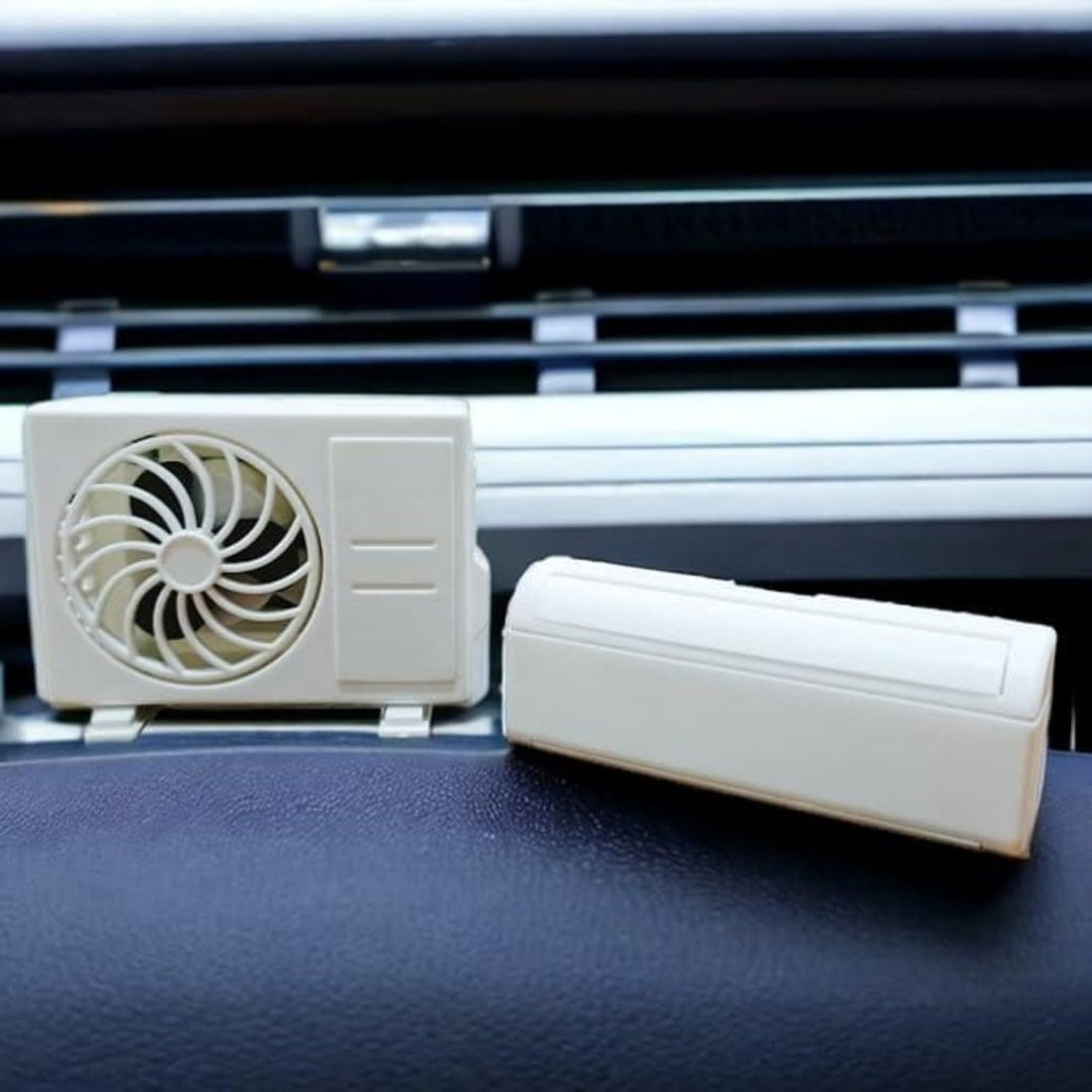 Small air conditioning unit and fan on a car dashboard