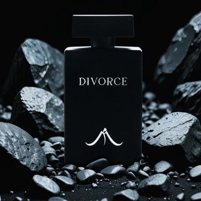 A black bottle of women's long-lasting perfume with the word 'DIVORCE' printed on it, surrounded by stones and rocks.