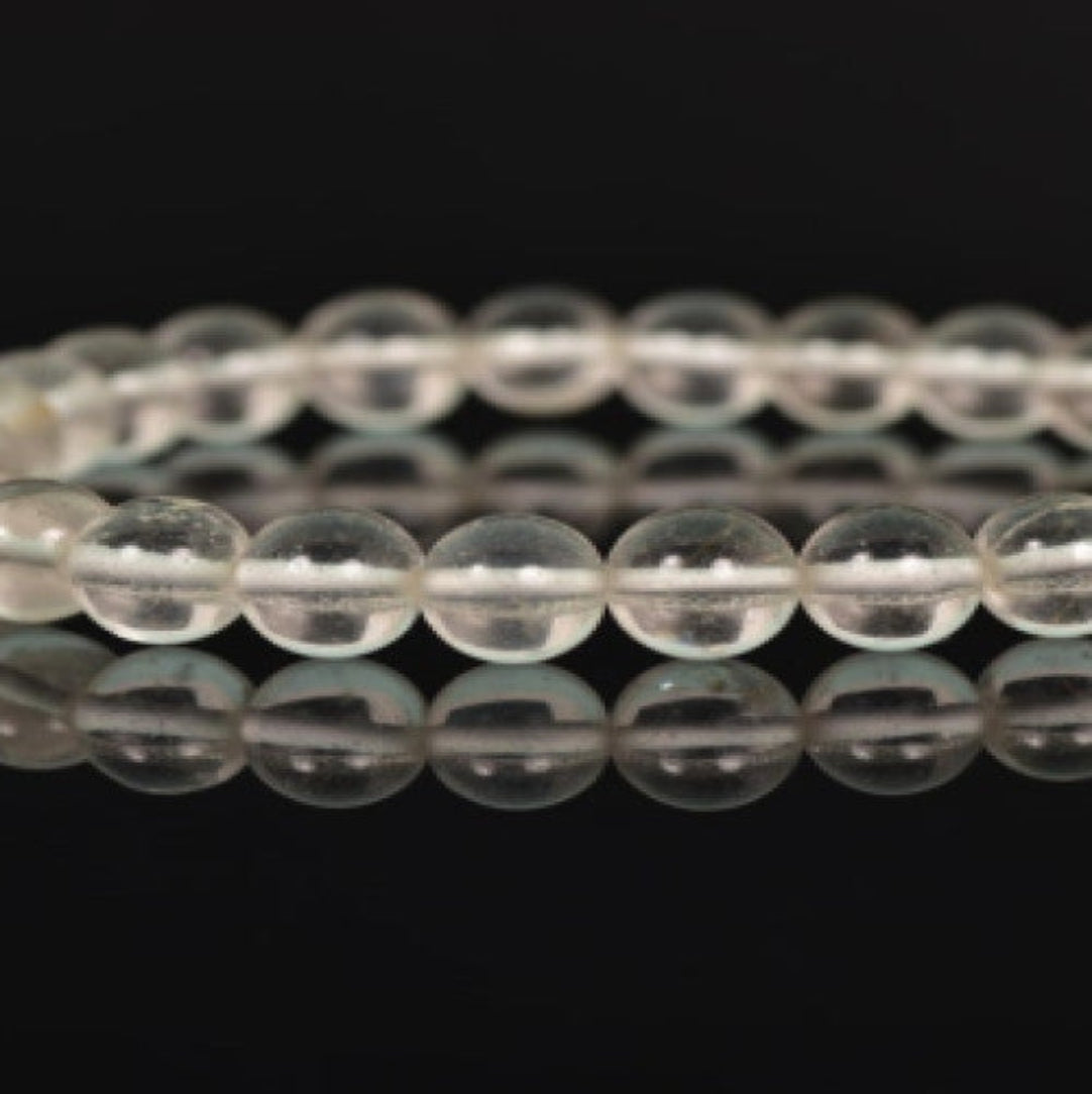A stretch-fit, handmade bracelet made with high-quality quartz beads, displayed against a dark background.