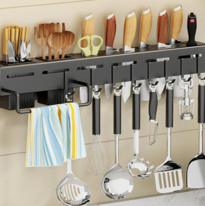 Stainless steel floating shelves mounted on a wall, equipped with a knife holder featuring various kitchen utensils.