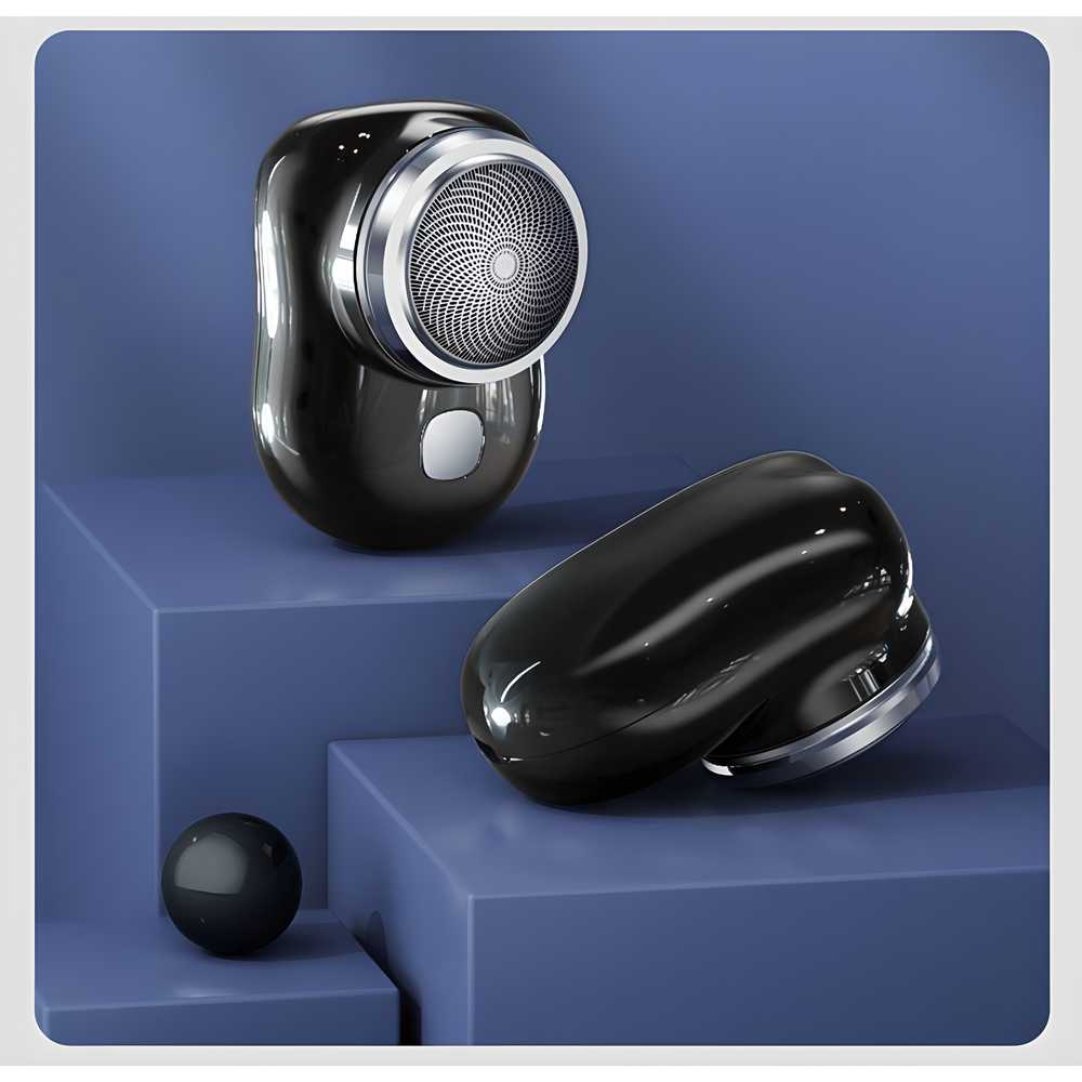 A mini electric shaver with a glossy black finish, displayed on a geometric blue stand with a closed case beside it.