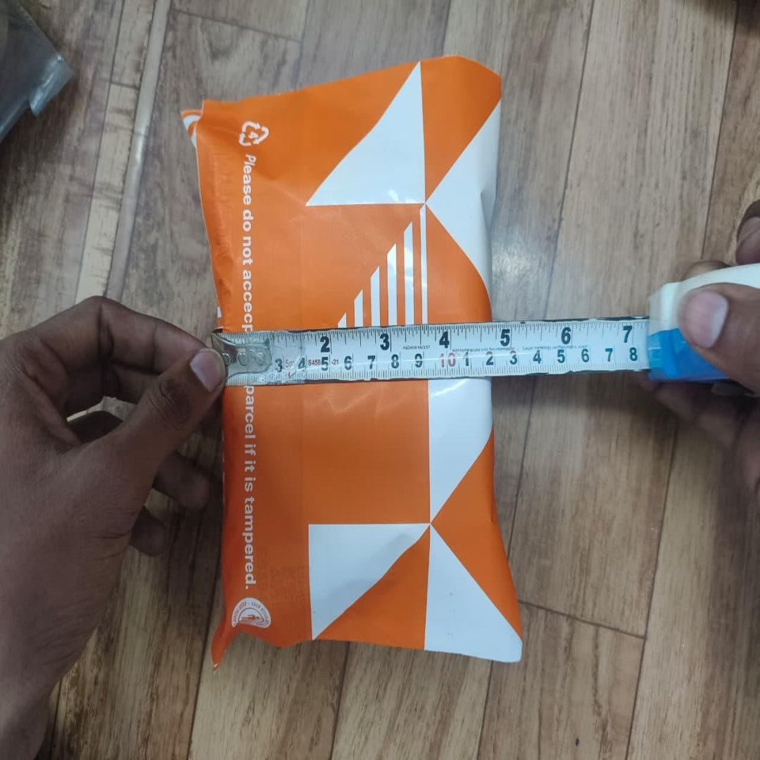 Orange and white package with a measuring tape on a wooden surface