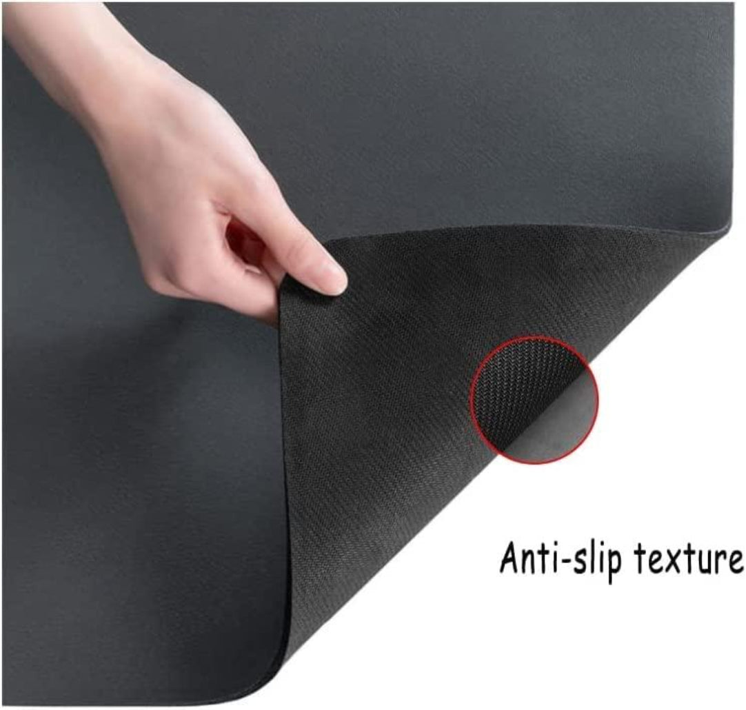 Black mat with anti-slip texture being held by a hand, showing close-up of textured area.