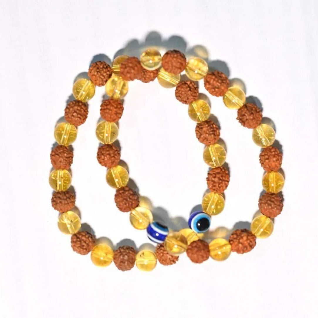 Two beaded bracelets with orange and yellow beads and a blue evil eye charm on a white background.