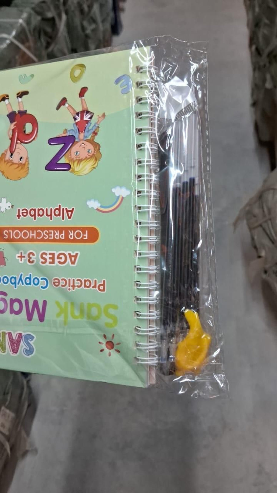 Children's alphabet book with pen and ruler on a textured surface