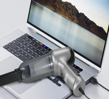 Small handheld vacuum cleaner connected to a laptop on a desk