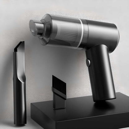 Silver handheld vacuum cleaner with attachments on a gray background