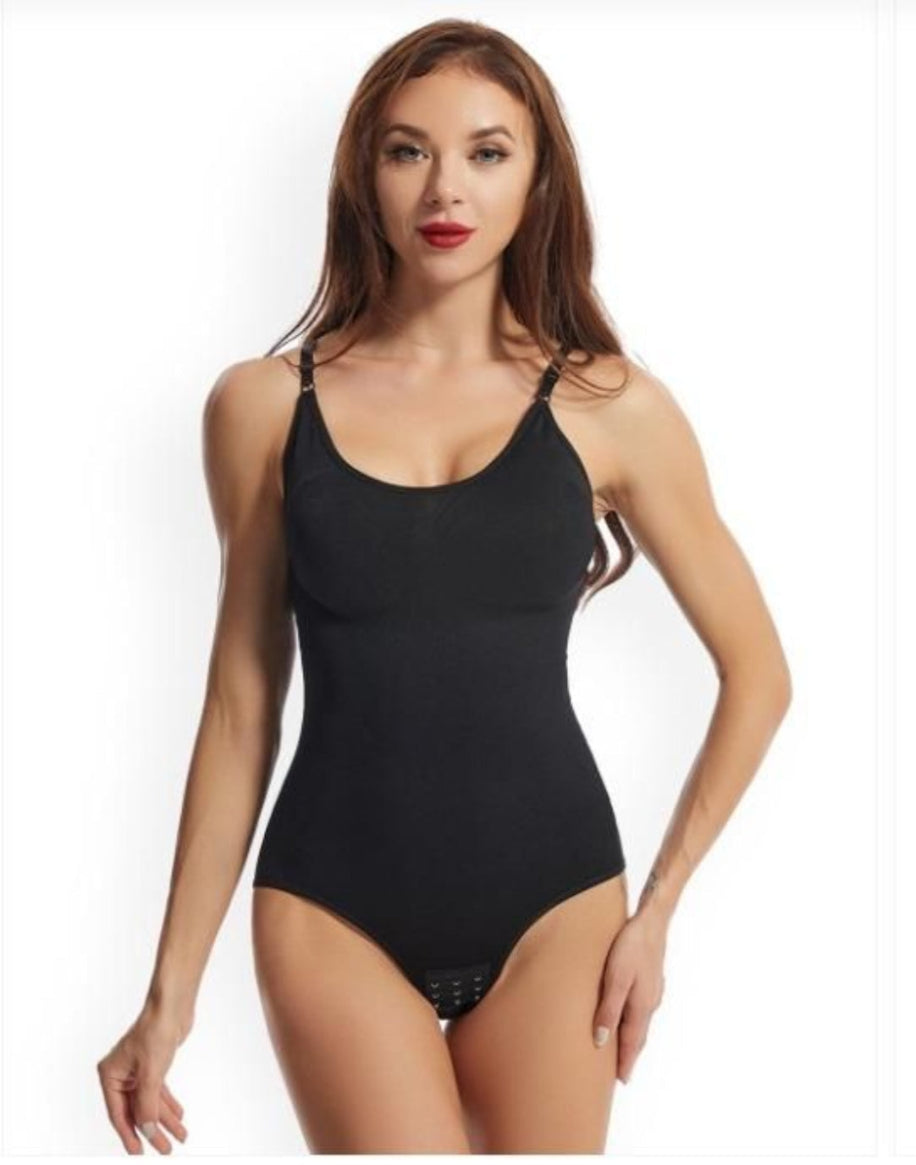 A woman wearing a solid black sleeveless body shapewear top with a V-neckline and a high waist design.