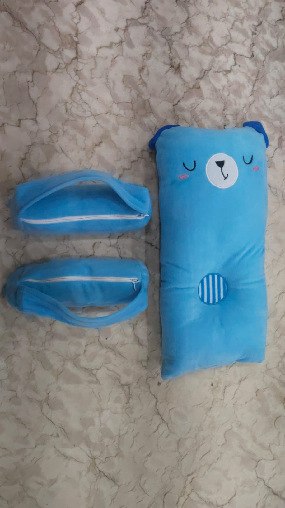 Blue cartoon bear-shaped pouch on a textured beige surface