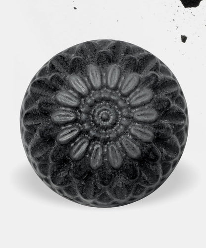 Black and white image of a decorative knob with floral pattern on a white background