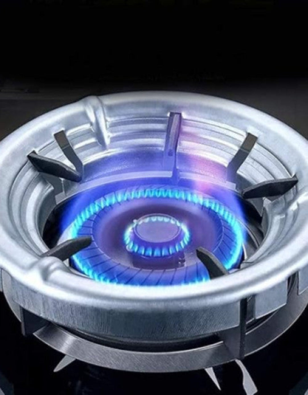 Gas stove burner with blue flame on a black background