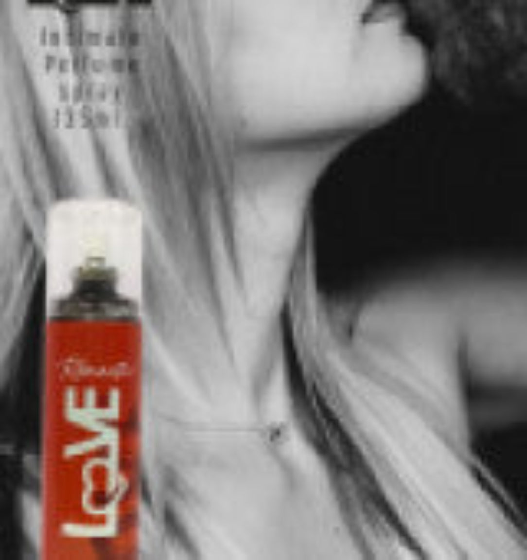Red can of hair spray with 'LOVE' branding held by a person with gray hair.