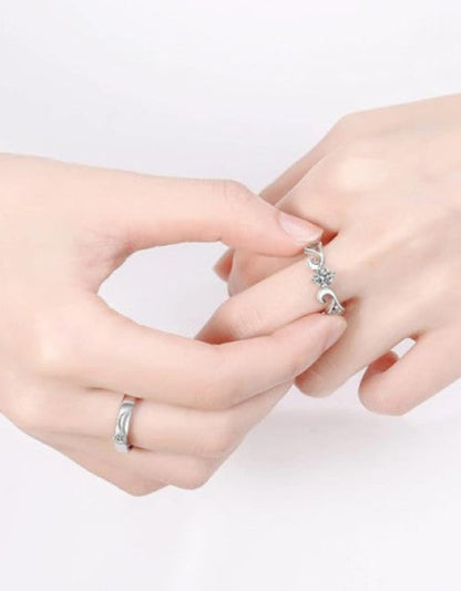 Two hands wearing silver rings on a white background