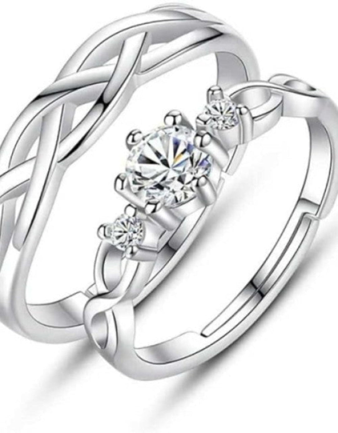 Pair of silver rings with interwoven design and clear gemstones on a white background