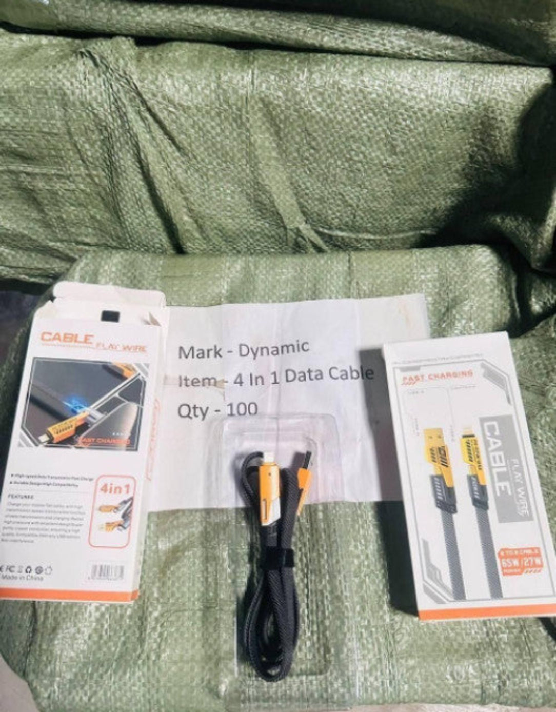 4-in-1 data cable with packaging on a green textured surface