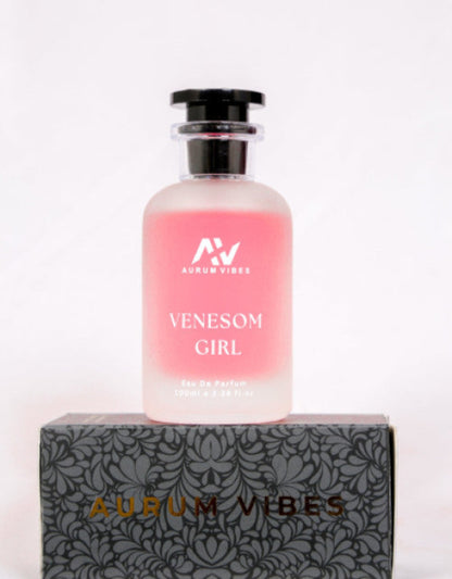 Pink perfume bottle labeled 'Venesom Girl' by 'Aurum Vibes' on a decorative box with the brand name.